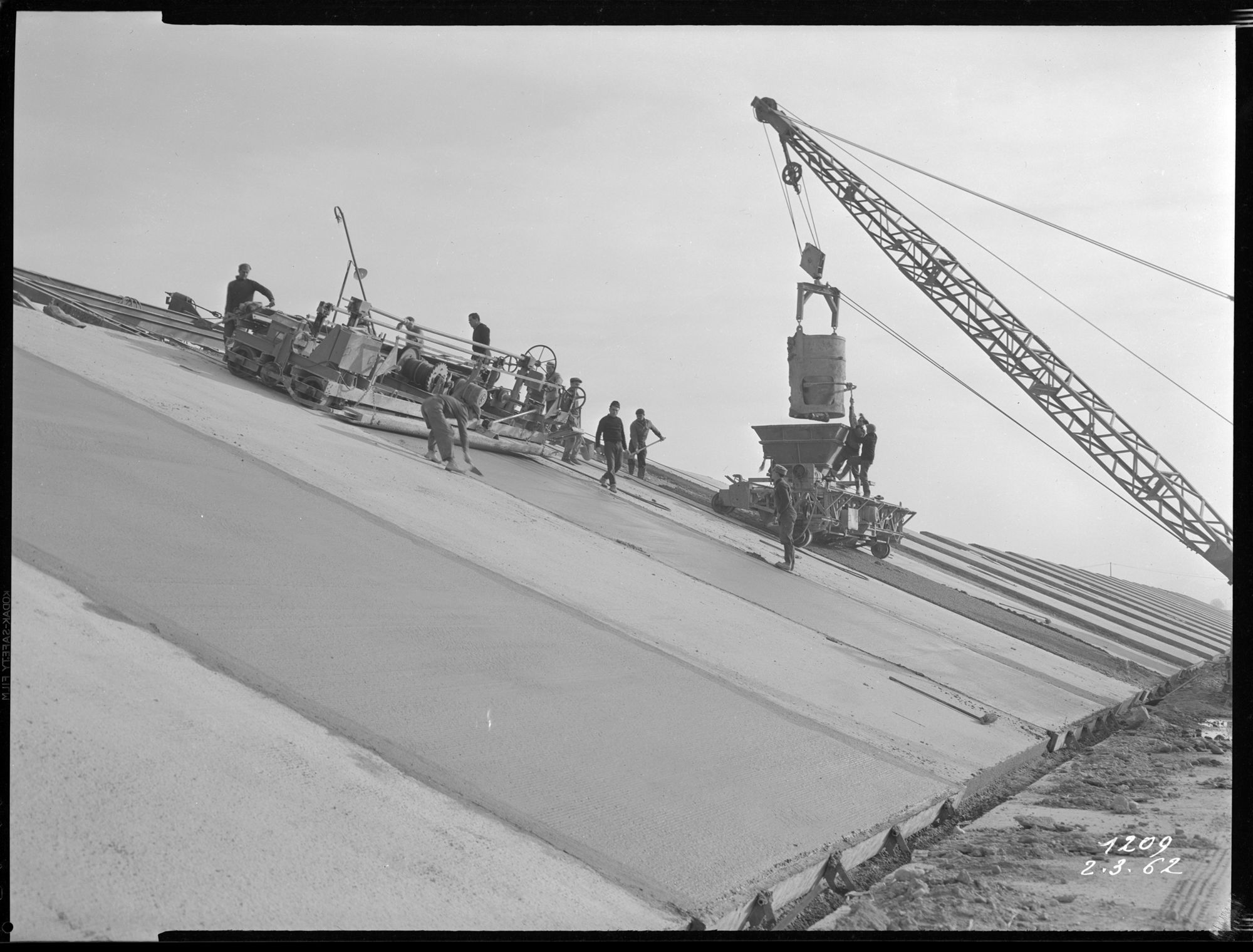 Pose du béton sur les murs inclinés du canal, machines, ouvriers