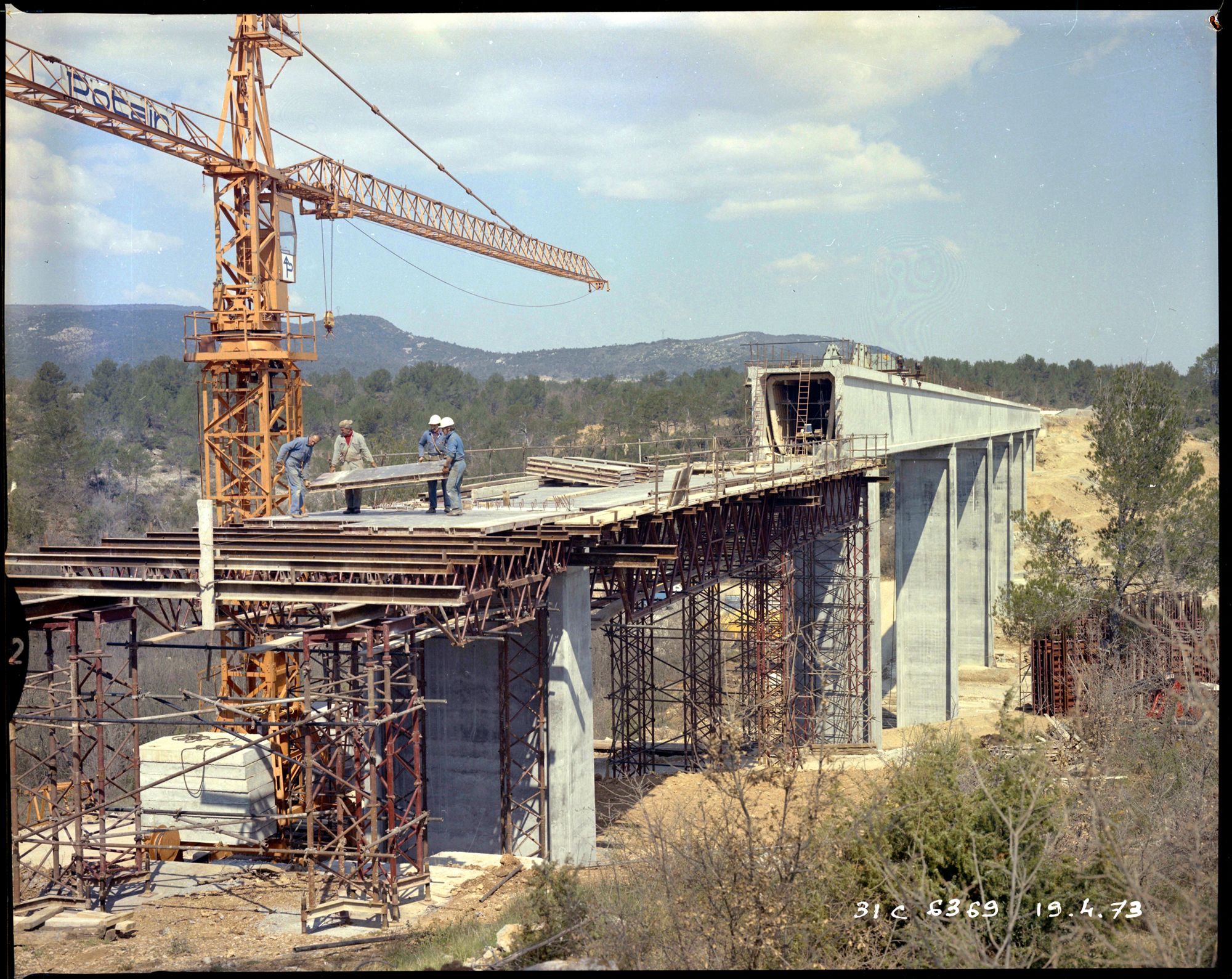 Ouvriers sur la partie supérieure horizontale du pont, ferraille, béton, grue