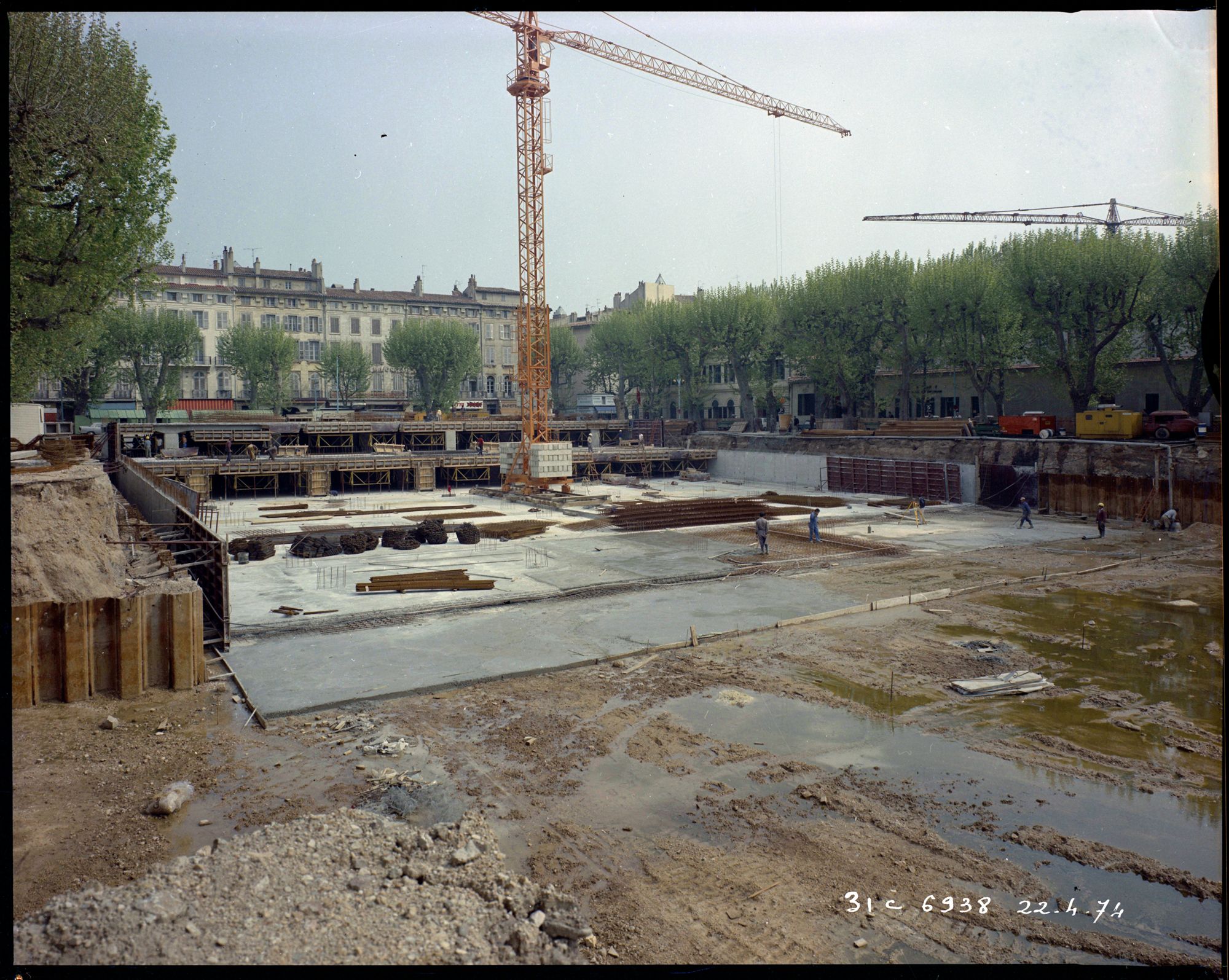 Chantier de construction du parking souterrain : deux niveaux, ouvriers, grue