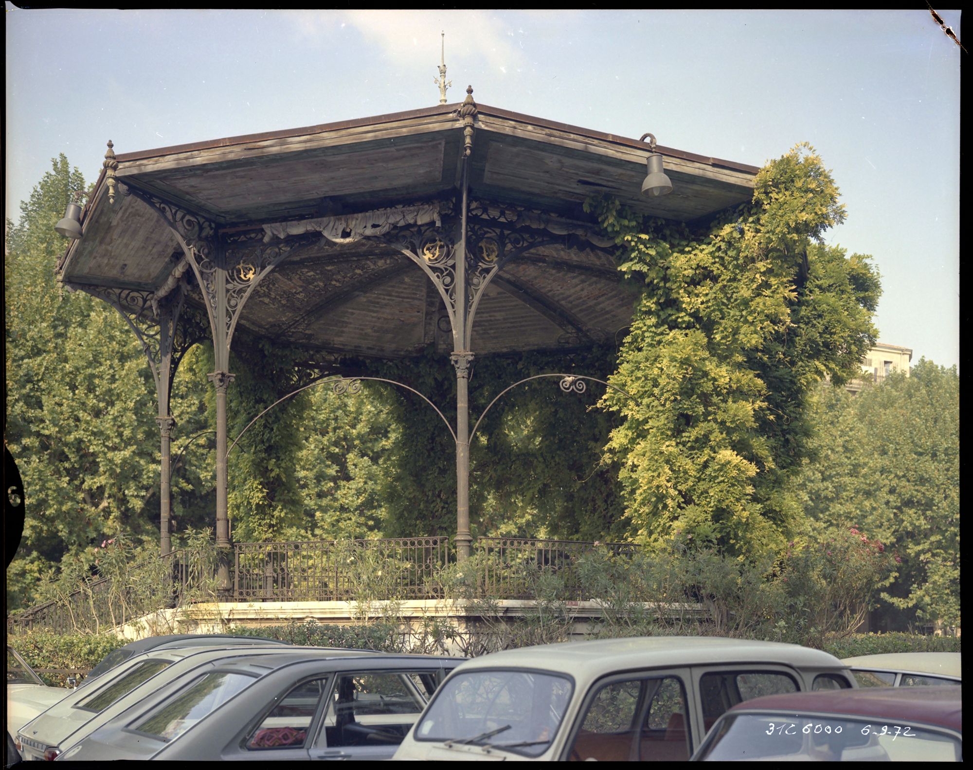 Kiosque à musique, voitures garées au premier plan